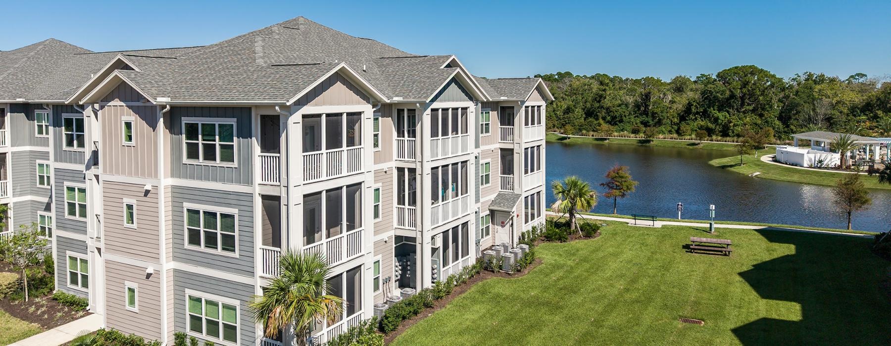 a large white house with a pond in the front