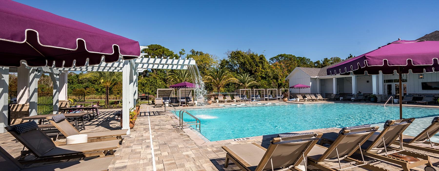 a pool with lounge chairs around it